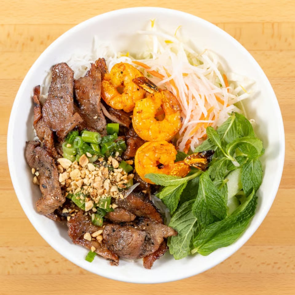 Bún Thịt Nướng Chả Giò, a Vietnamese vermicelli bowl with grilled pork, shrimp, and fresh herbs.